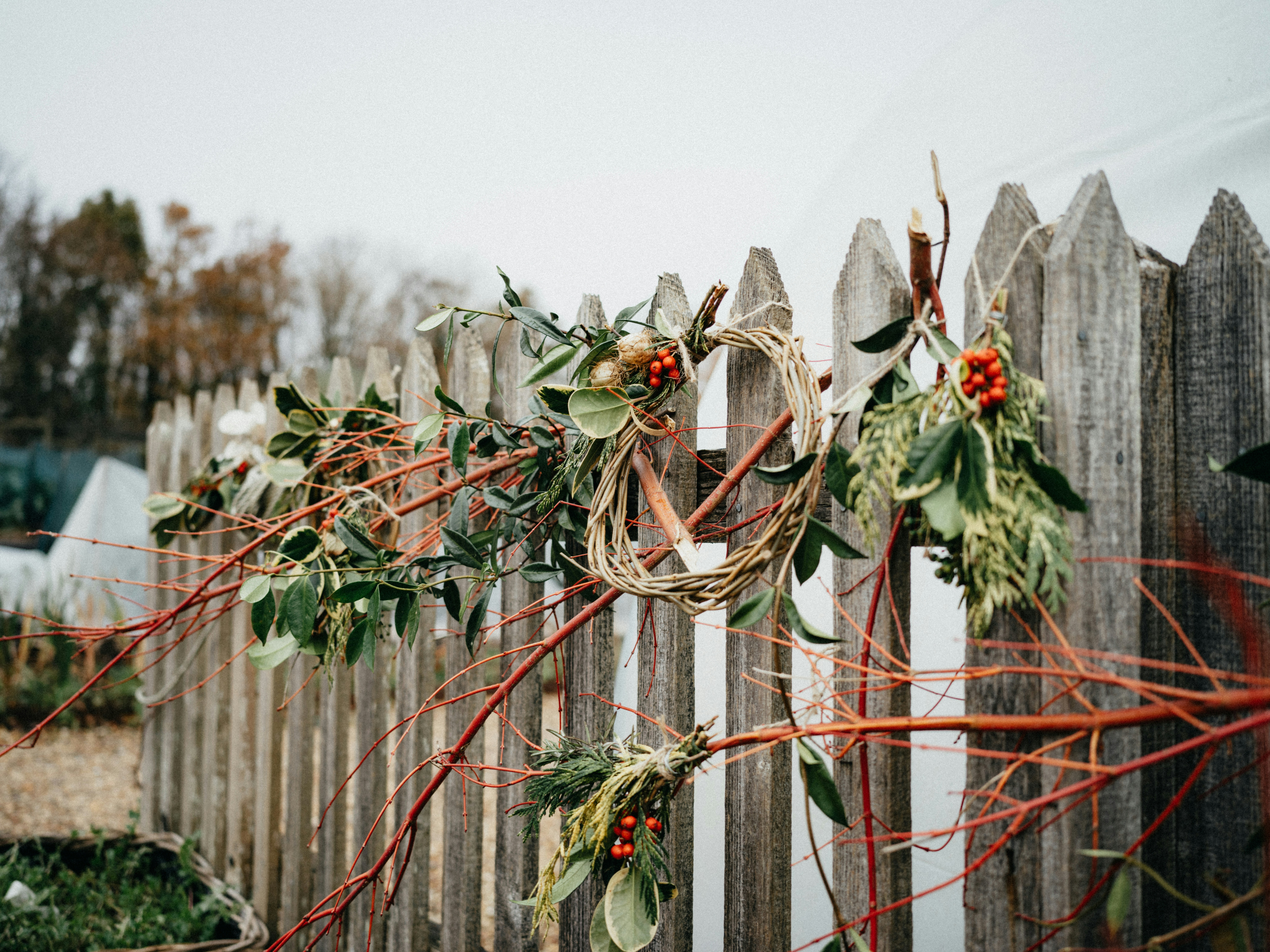 uma cerca de madeira com uma coroa de flores em cima