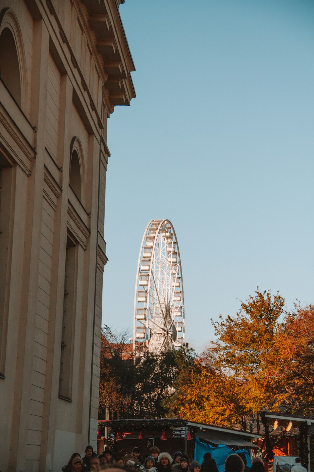 a crowd of people standing around a ferris wheel