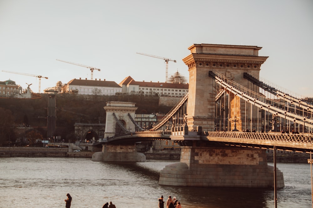 a group of people standing on the side of a bridge