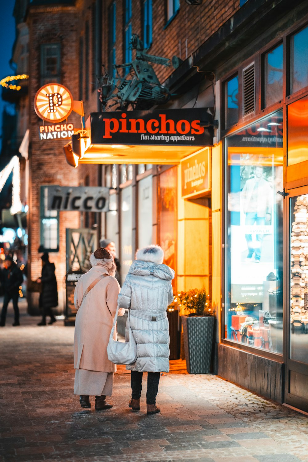 a couple of people that are standing in front of a store