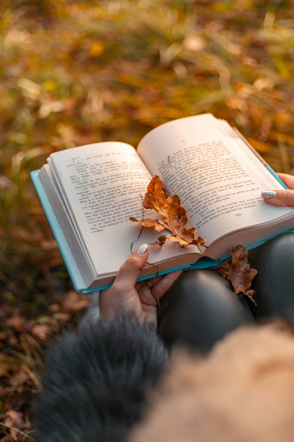 a person is reading a book in the grass