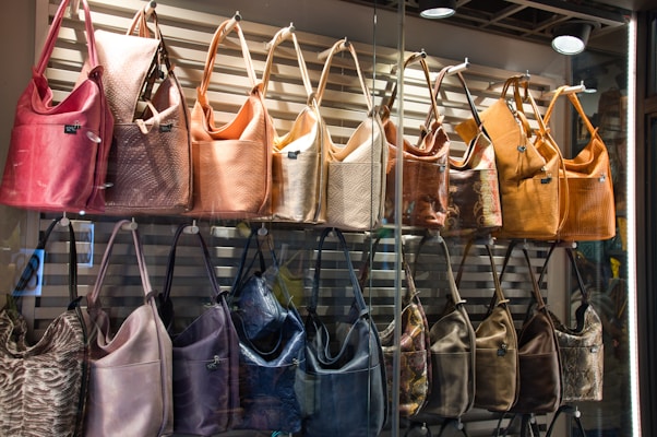 a bunch of purses that are hanging on a wall