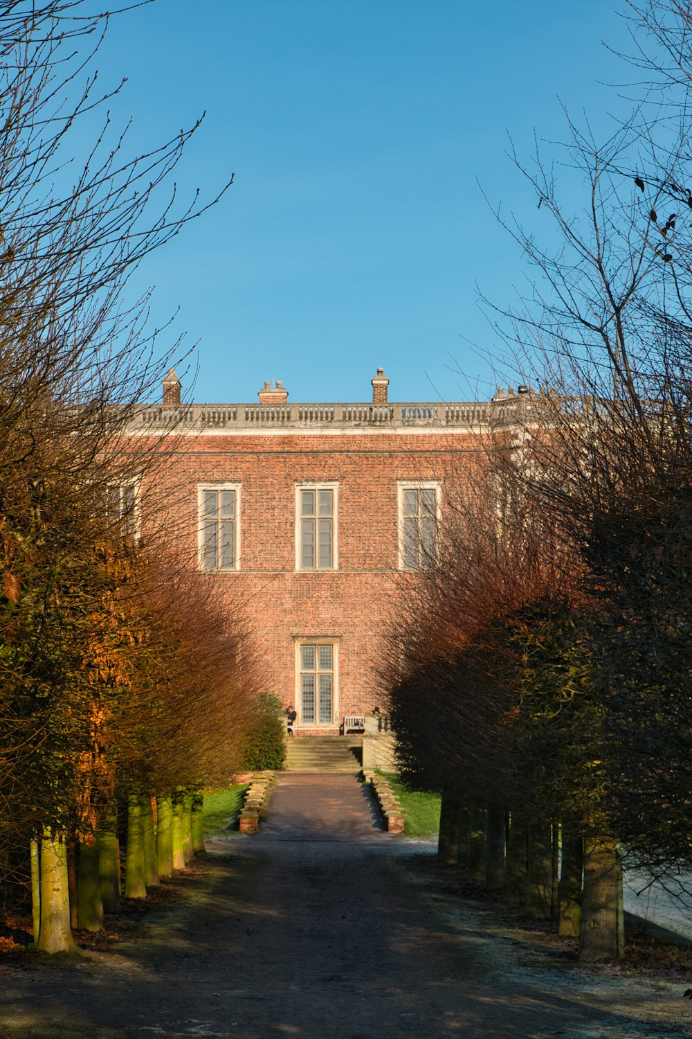 a brick building surrounded by trees and bushes