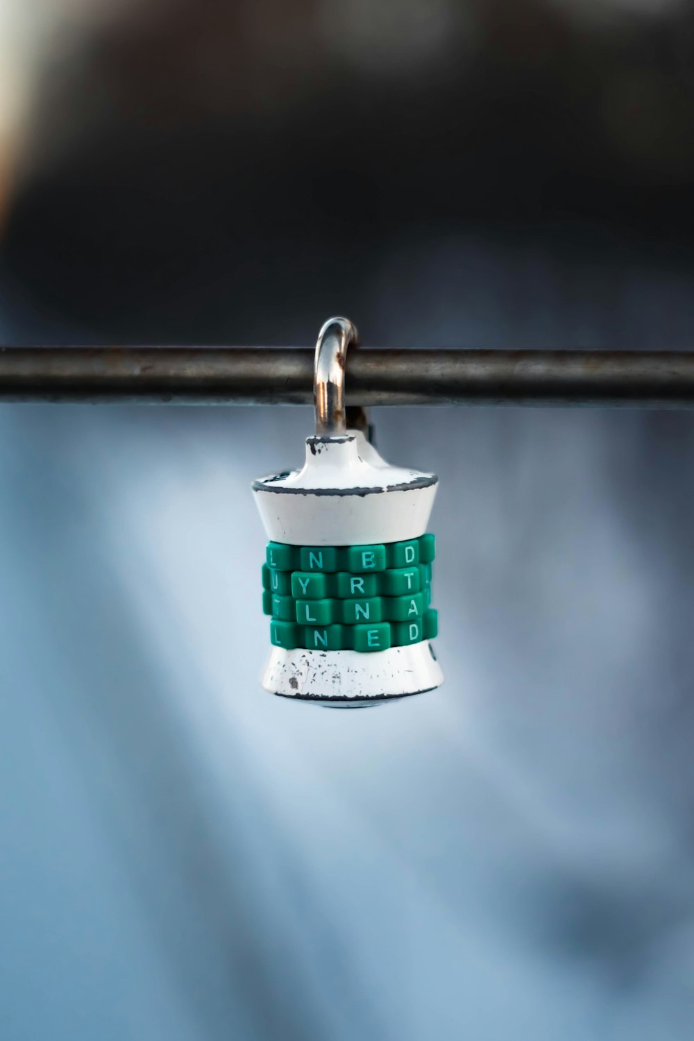 a green and white key chain attached to a metal pole
