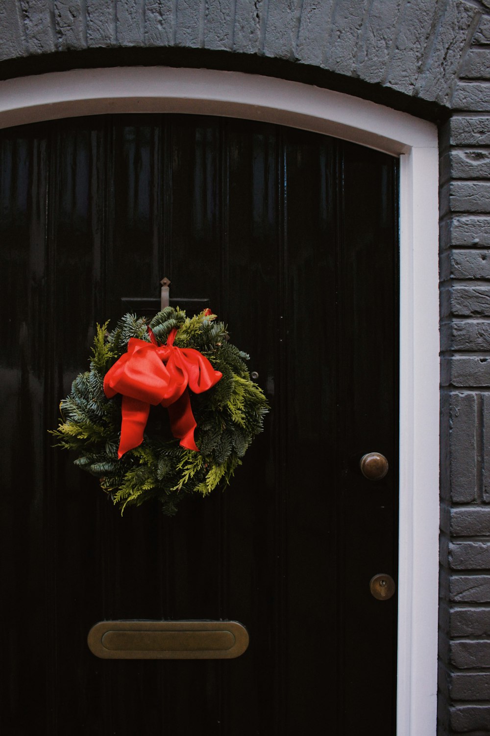 a door with a wreath and a red bow on it