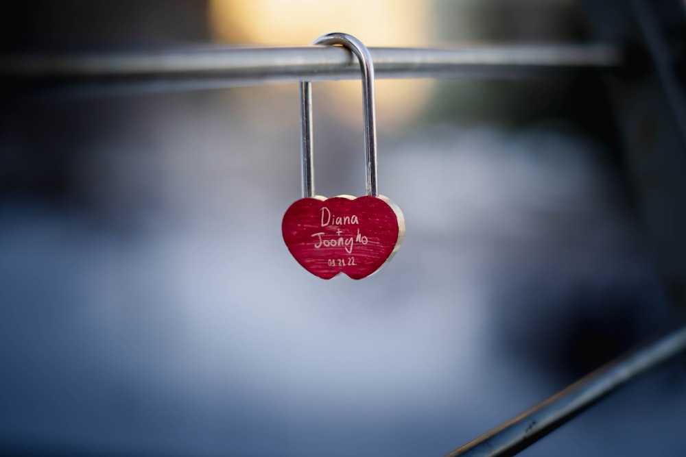 a red heart hanging from a metal bar
