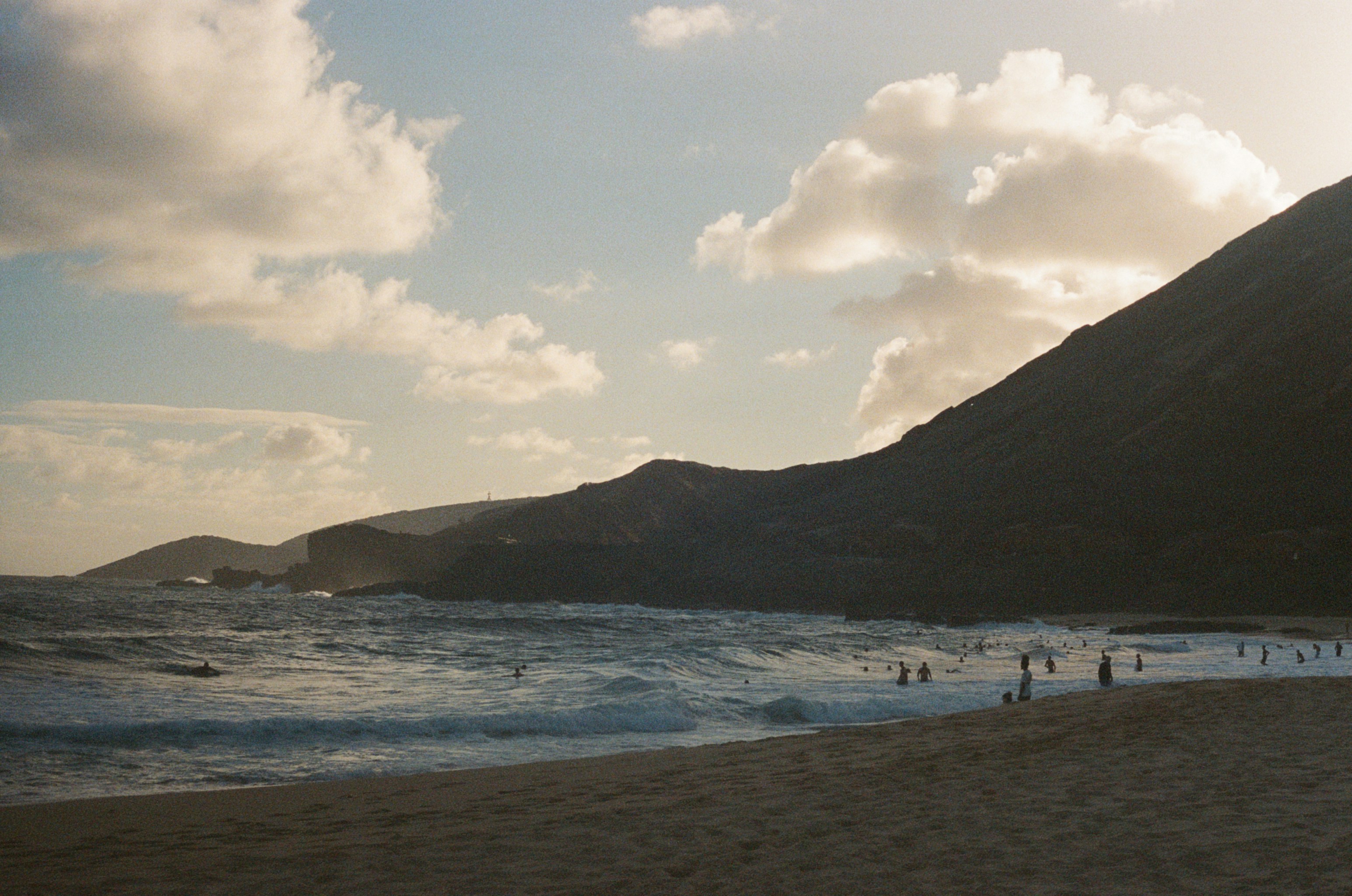 a group of people standing on top of a sandy beach