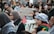 A diverse crowd is gathered, holding signs with messages of unity and support for Palestine. Many individuals wear winter clothing, with some wearing face masks. The signs are prominently displayed, indicating themes of solidarity.
