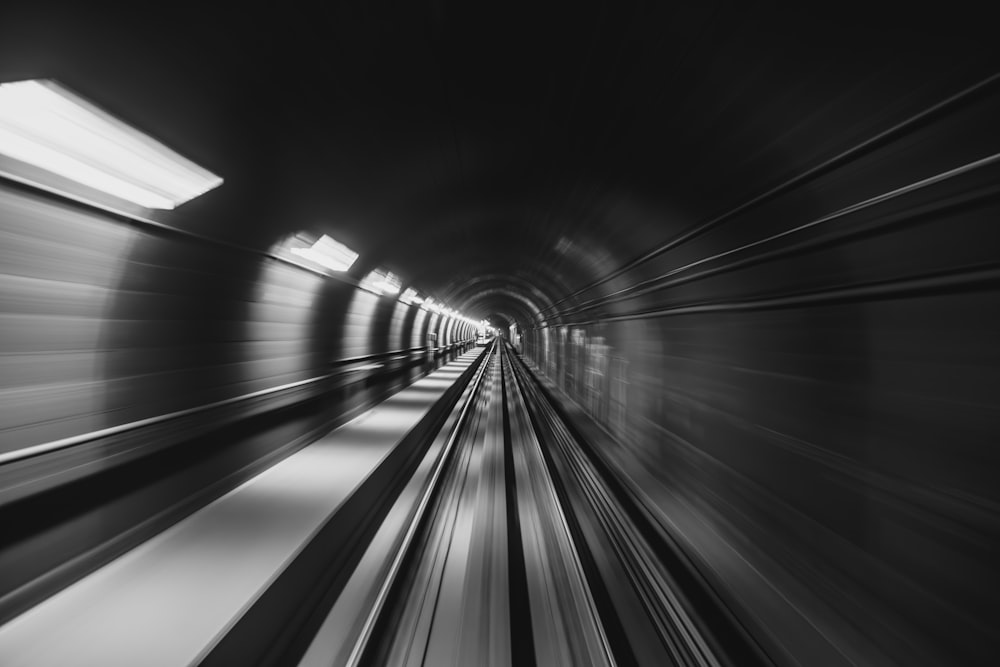 a black and white photo of a train going through a tunnel