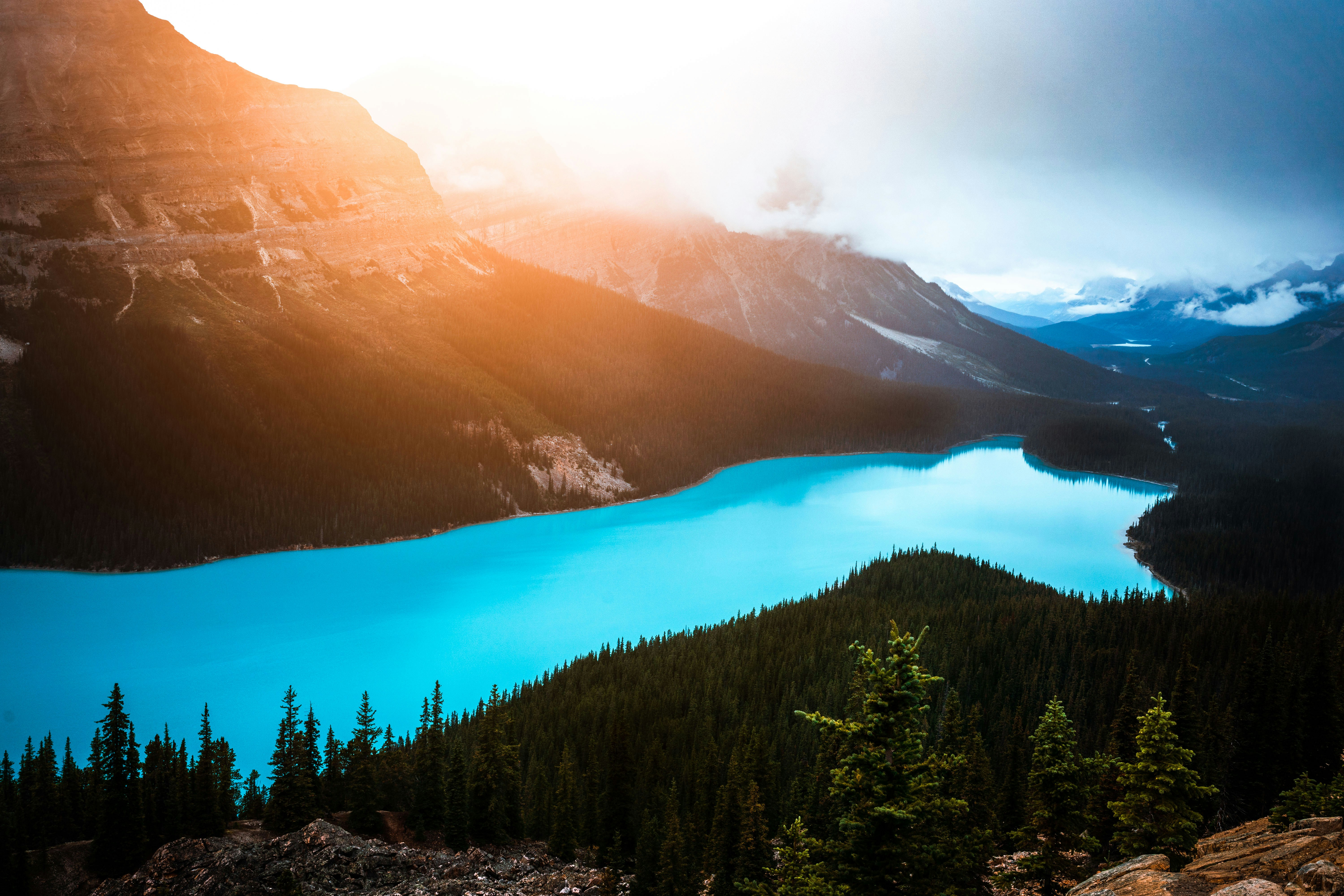 a blue lake surrounded by mountains and trees, 