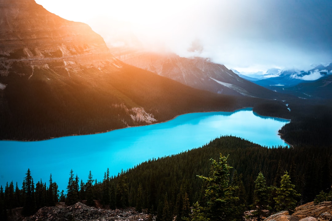 a blue lake surrounded by mountains and trees,