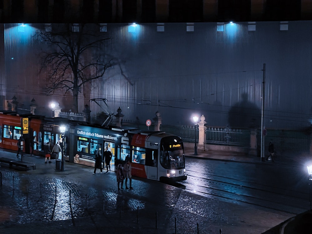a city street at night with a bus on the street