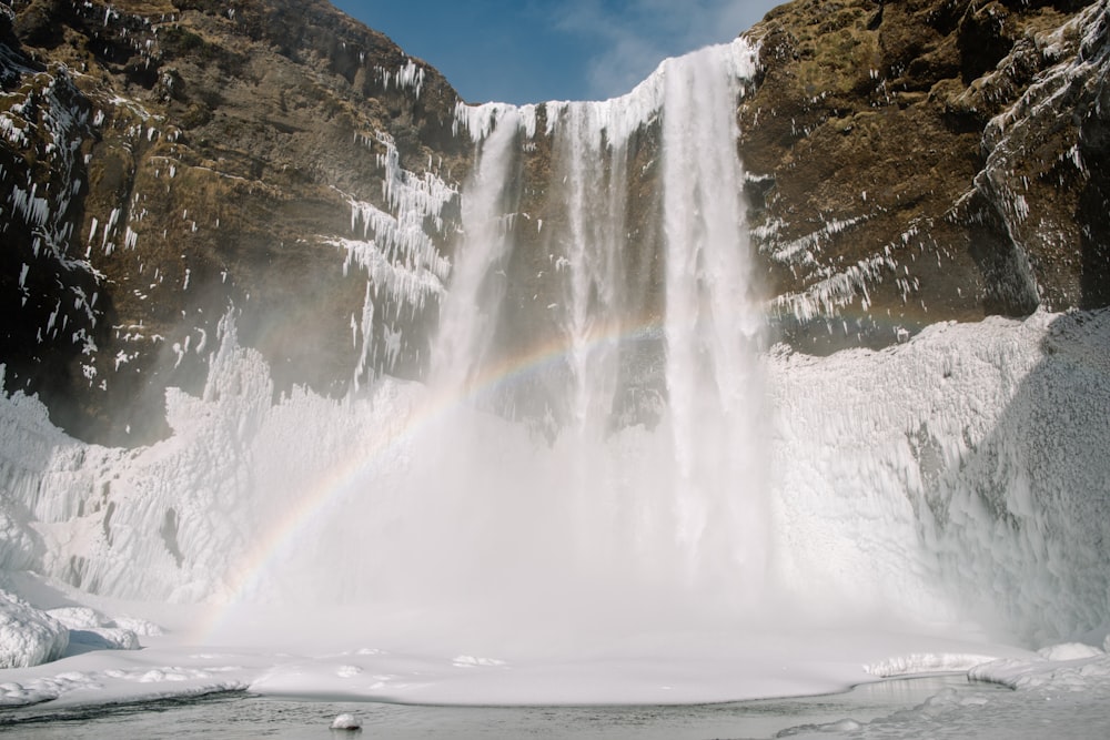 ein Wasserfall mit einem Regenbogen in der Mitte