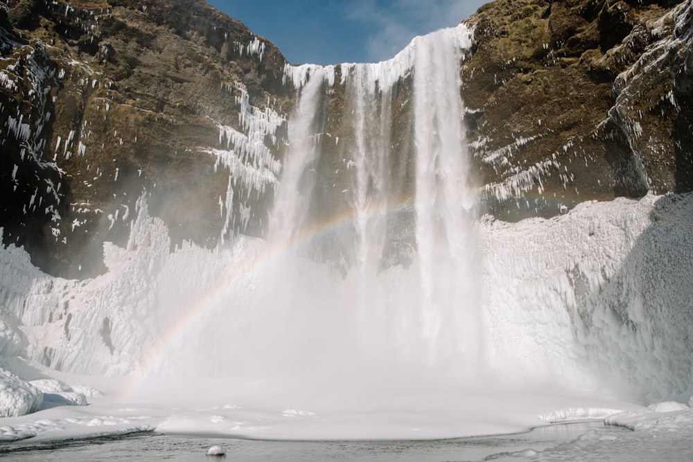 a waterfall with a rainbow in the middle of it