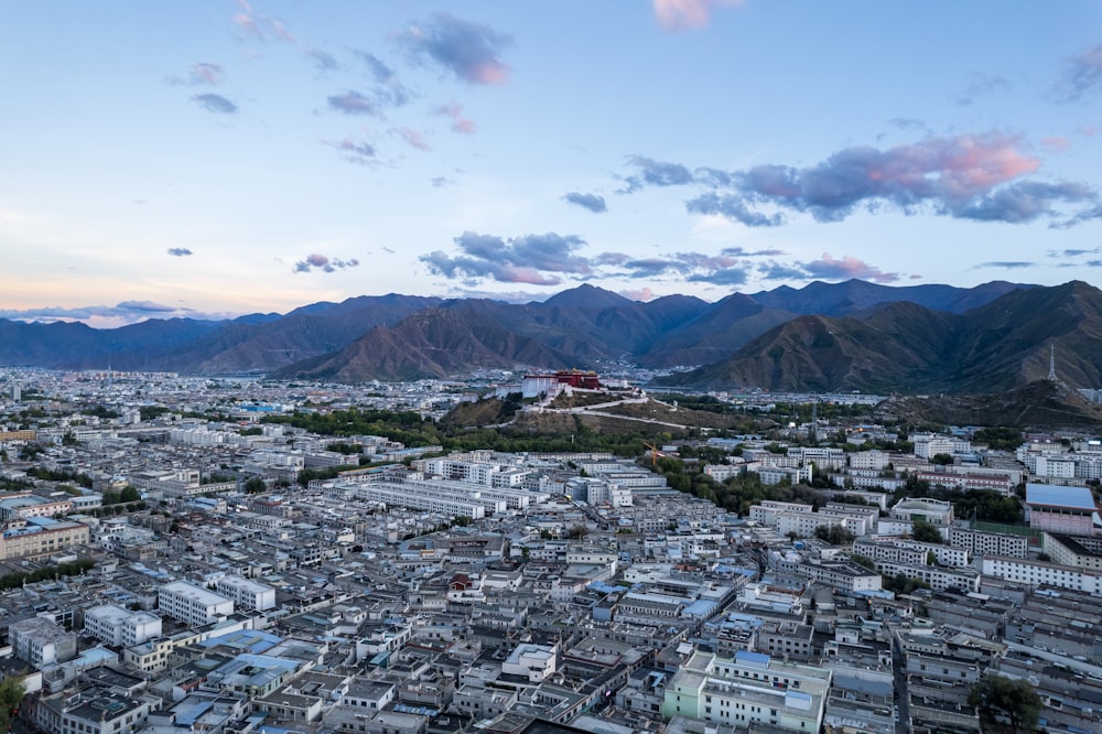 an aerial view of a city with mountains in the background