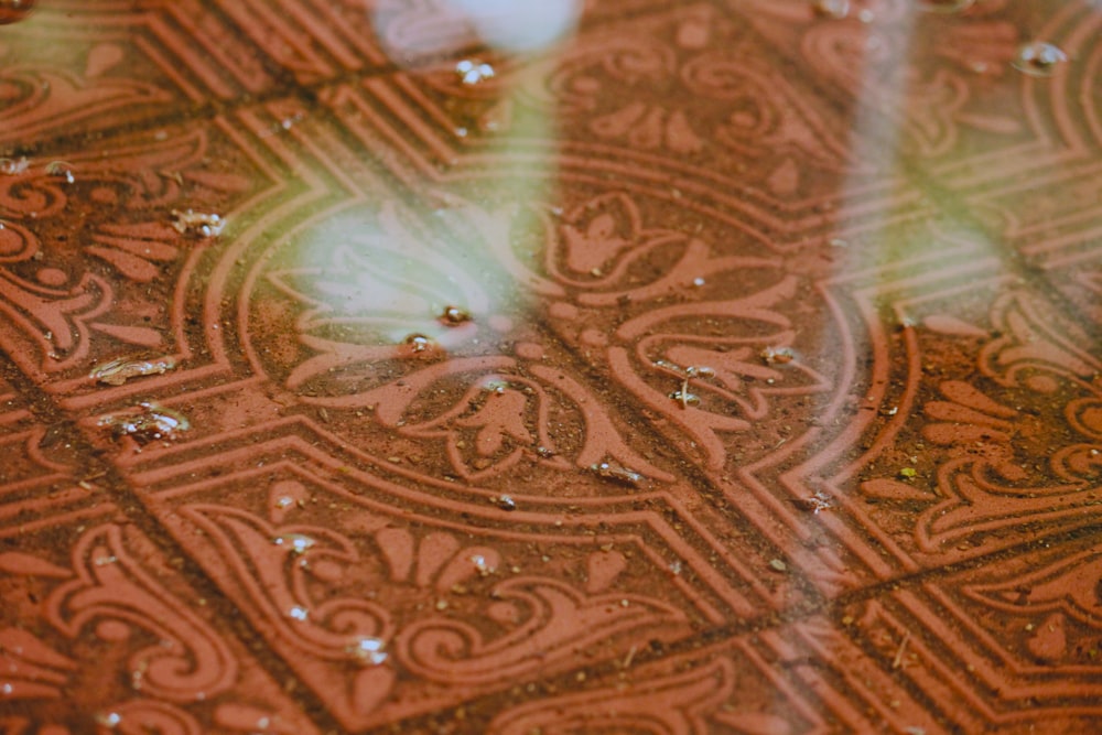 a close up of a tile floor with drops of water on it