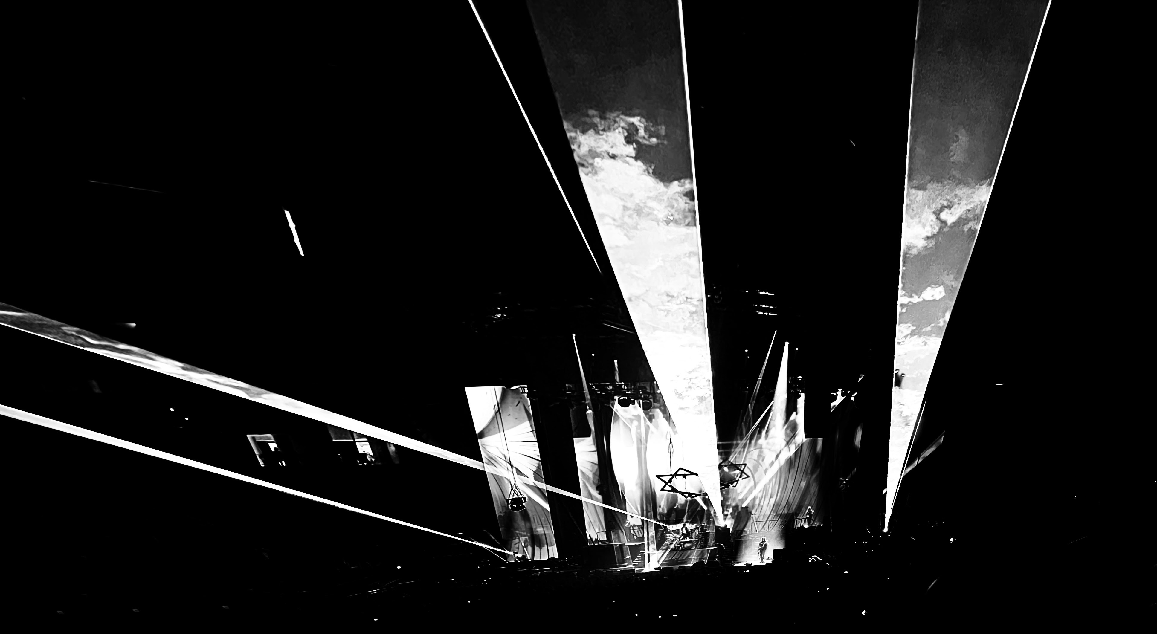 Concert stage with dramatic light show, deep shadows and bright beams