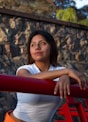 a young woman leaning on a red railing