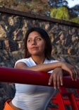 a young woman leaning on a red railing