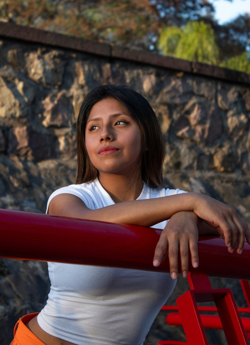 a young woman leaning on a red railing