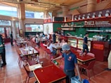 Friendly staff serving customers at a bustling restaurant counter.