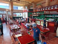 A close-up of a young restaurant worker passionately engaging with customers at a bustling eatery.
