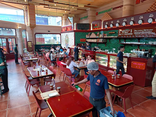 A bustling dhaba interior with colorful decor and wooden tables.