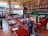A satisfied restaurant owner discussing innovations with staff in a vibrant dining area.