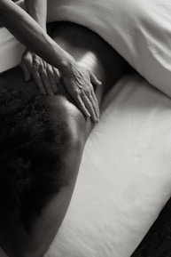 a person laying on a bed with their hands on their back