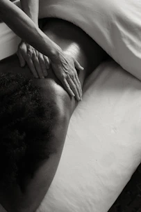 a person laying on a bed with their hands on their back