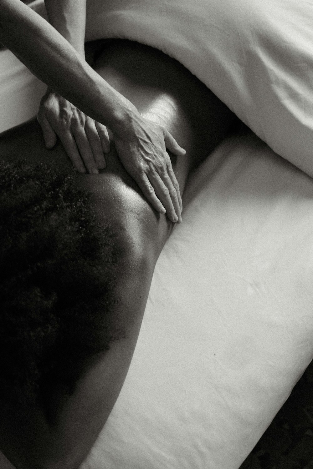 a person laying on a bed with their hands on their back