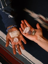 A close-up of hands holding glowing crystals, representing energy and balance.