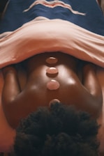 a woman laying on top of a bed under a blanket