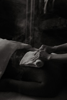 a black and white photo of a person laying in a bed