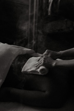 a black and white photo of a person laying in a bed