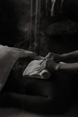 a black and white photo of a person laying in a bed