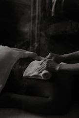 a black and white photo of a person laying in a bed
