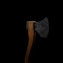A single axe with a wooden handle and a dark, roughly textured metal head is set against a plain black background.