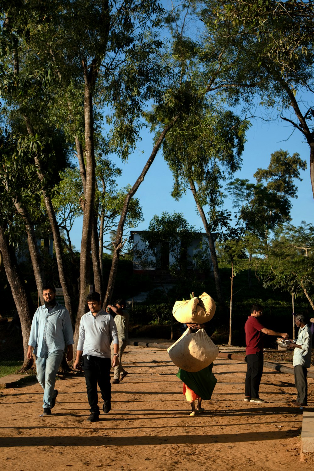 a group of people walking down a dirt road