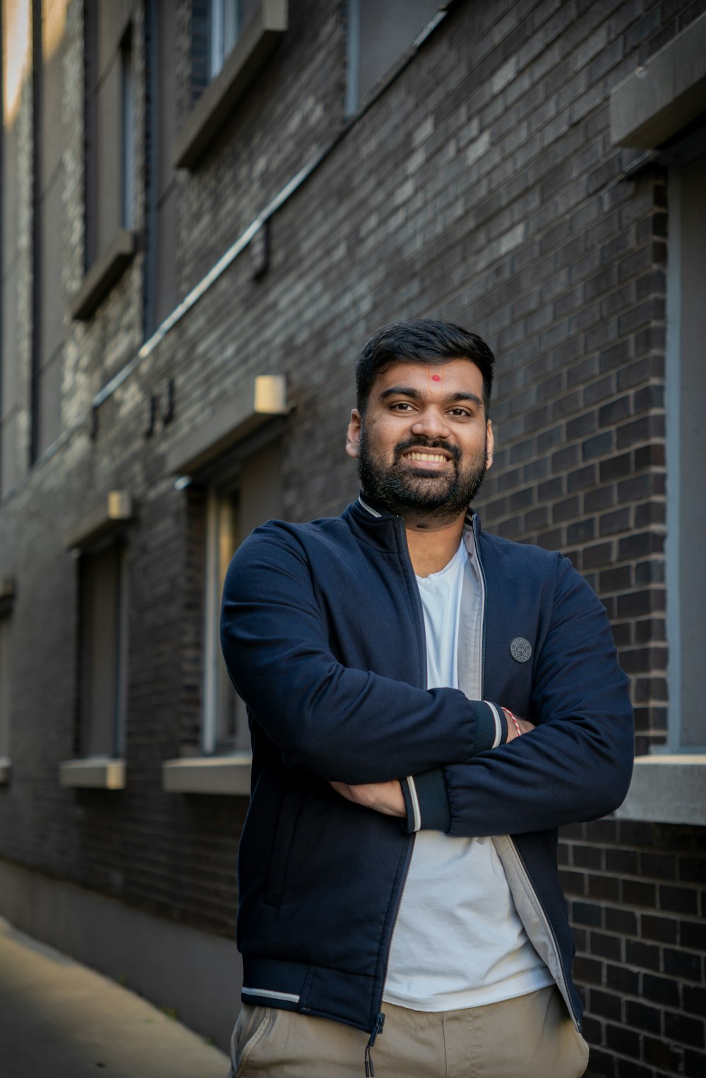 a man standing in front of a brick building