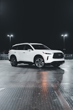 Side view of a black SUV with a custom side step glowing under soft lighting.