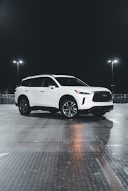 Side view of a black SUV with a custom side step glowing under soft lighting.