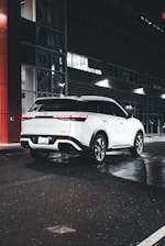 A clean, white vehicle from the Signature tier waiting at a city curb.