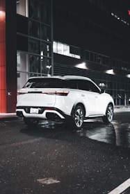 A clean, white vehicle from the Signature tier waiting at a city curb.