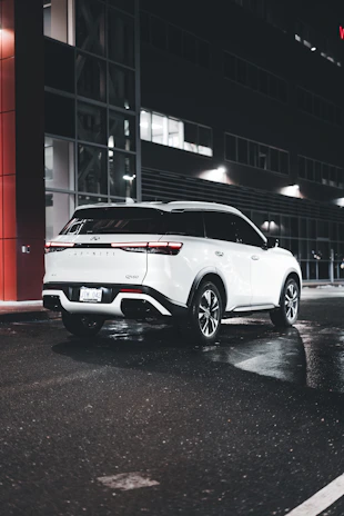 A sleek moving truck parked outside a modern city apartment building at sunset.