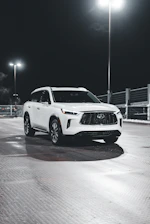 A clean SUV parked beside a sparkling water spray, showcasing a fresh car wash.