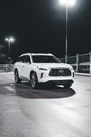 A sleek SUV with a mirror-like paint correction finish parked under soft lighting highlighting its contours.