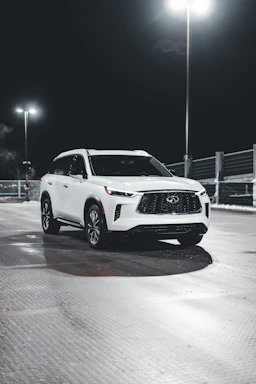 A clean SUV parked beside a sparkling water spray, showcasing a fresh car wash.