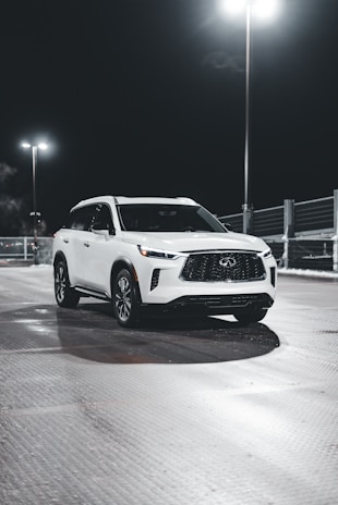 A sparkling white SUV after a thorough wash, reflecting the blue sky and studio lights.