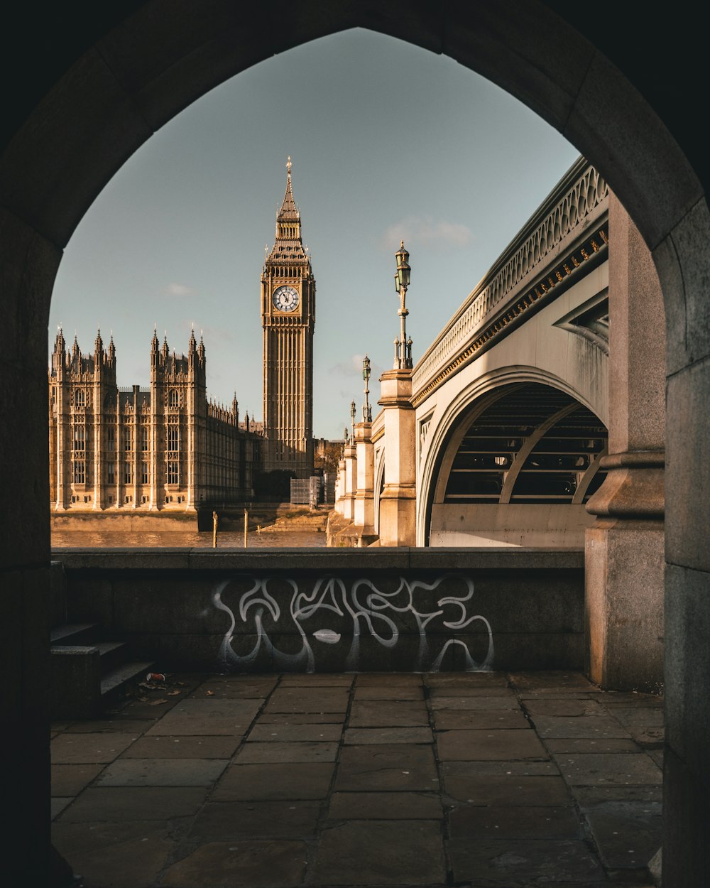 a clock tower towering over a city next to a bridge